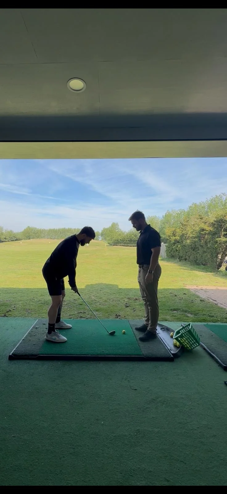 Thomas Coleiro coaching a golfer on the driving range
